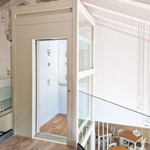 Lift in weiß mit Glastür und Glaswand im innern des Hauses