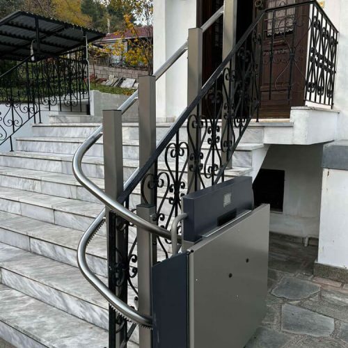 GTLE Plattform-Treppenlift installiert an einer Marmortreppe mit dekorativem Metallgeländer, geeignet für den barrierefreien Zugang zum Gebäude – ermöglicht sicheren Transport von Rollstuhlfahrern oder Personen mit eingeschränkter Mobilität über Treppen im öffentlichen oder privaten Bereich.